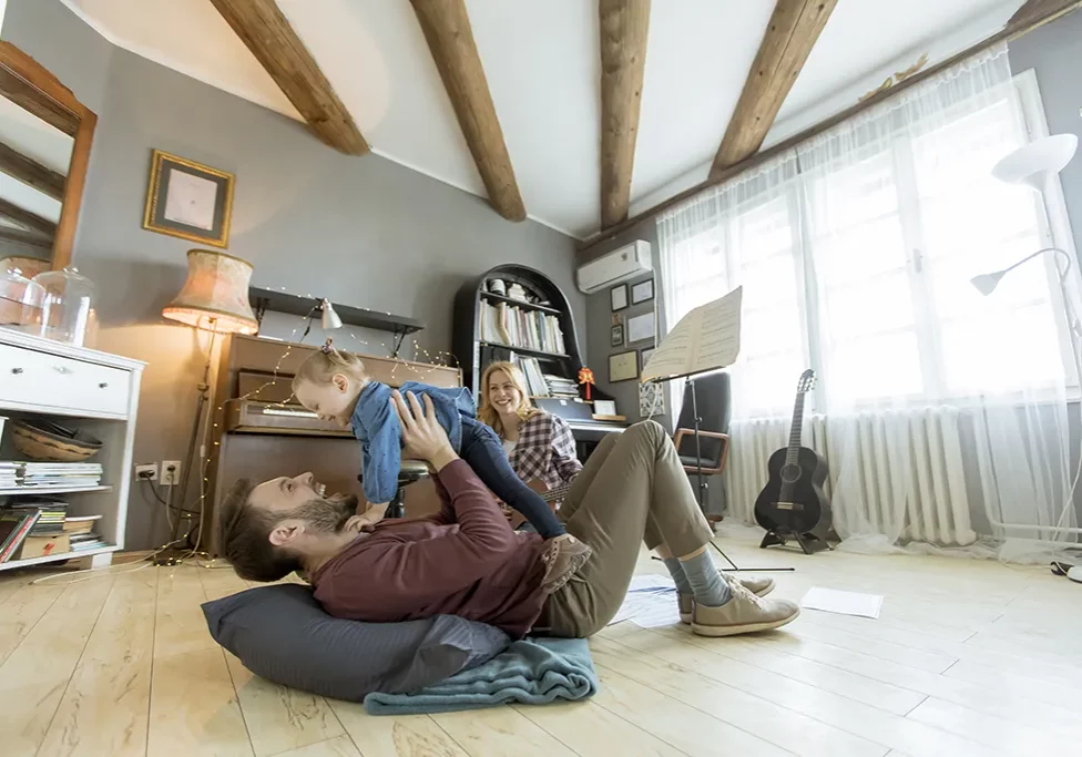 family-playing-in-sunlit-room-windows-doors-n-more-shelbina-mo Young family enjoying natural light in a cozy, window-filled room—highlighting the comfort and style possible with Doors N More window solutions in Shelbina, MO.